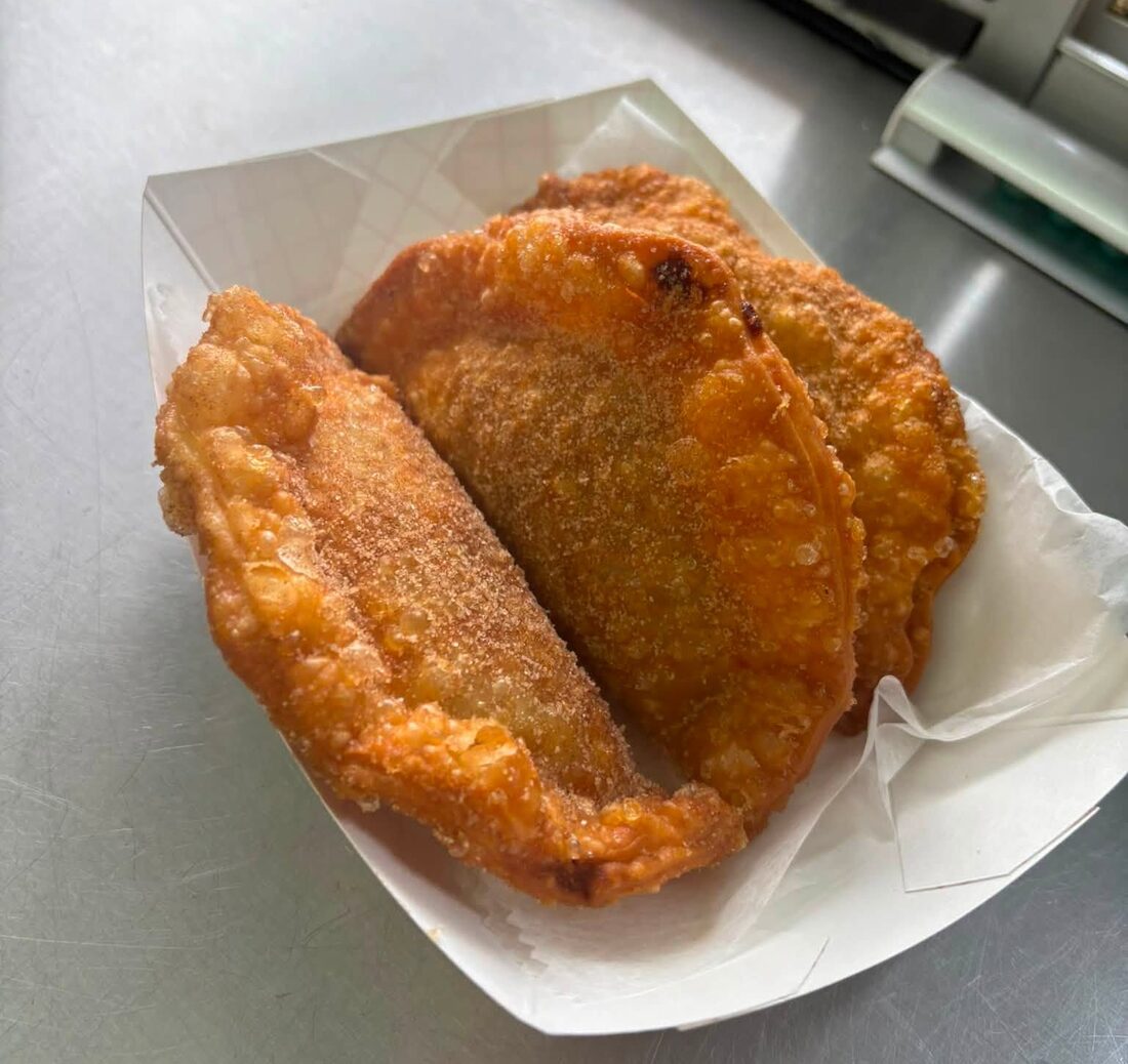 Fresh-fried empanadas in a paper boat