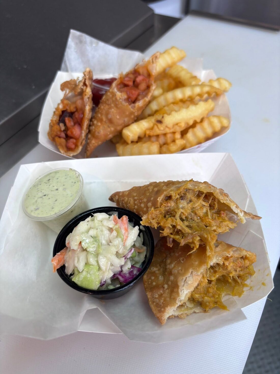 Pulled pork empanada cut open, with slaw and green sauce